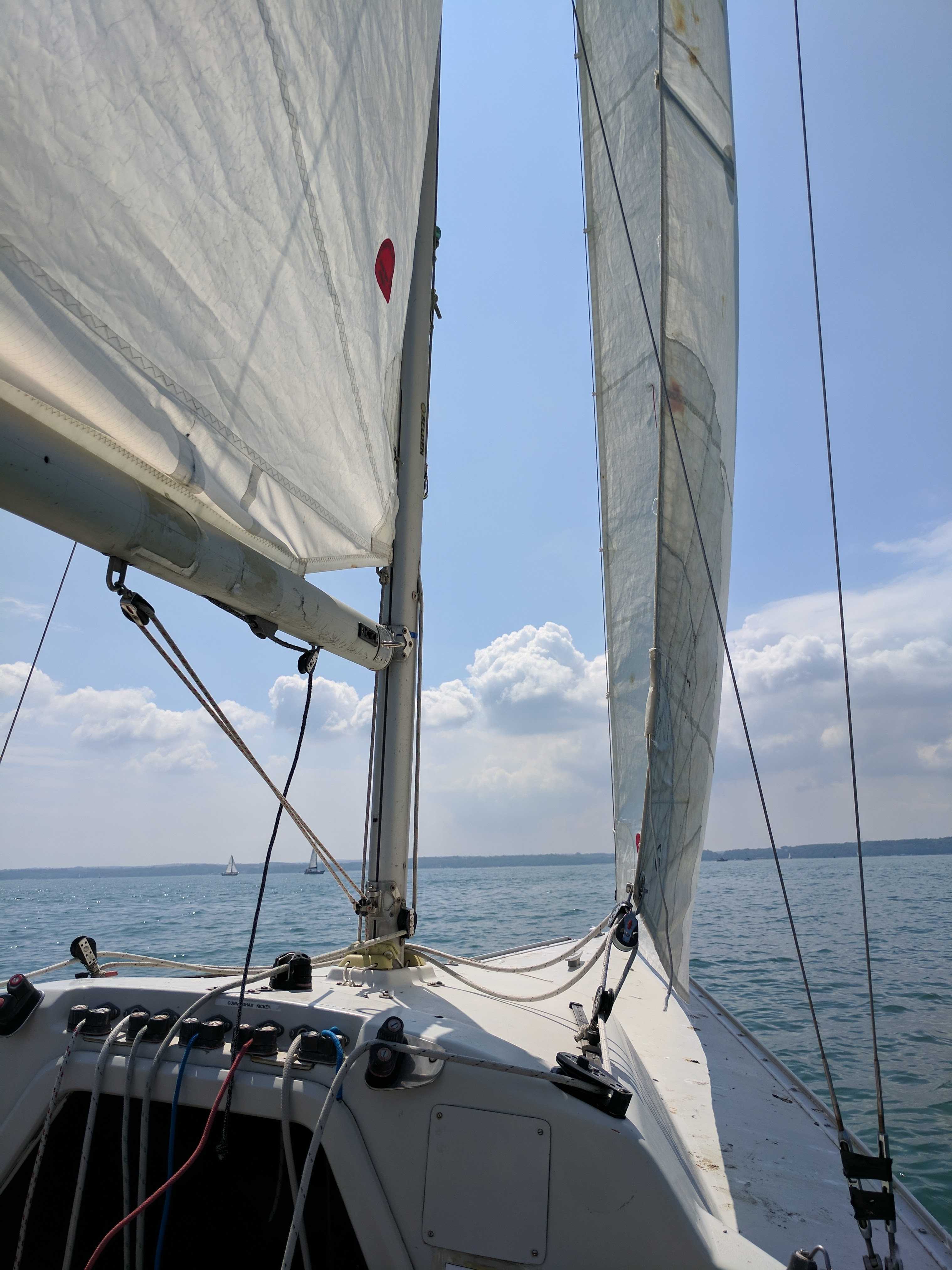 A small boat sailing off the coast of the Isle of Wight in very light winds.